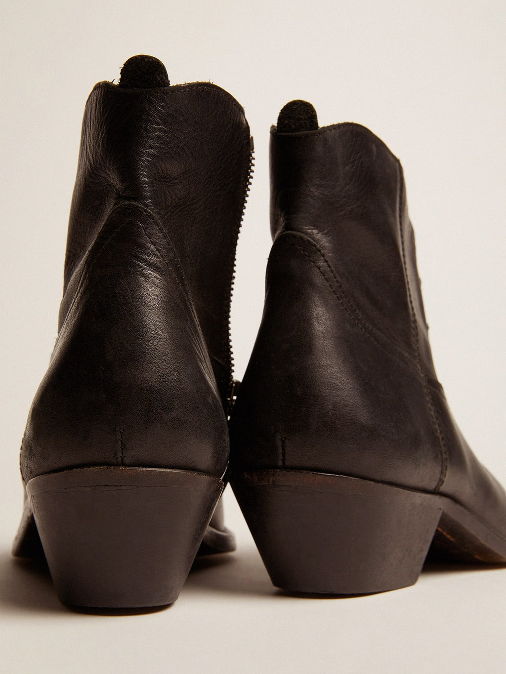 Young ankle boots in black leather with sand-colored embroidery